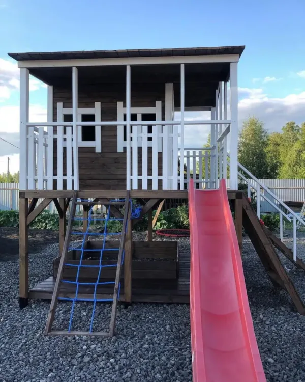 Wooden playhouse with slide and climbing wall