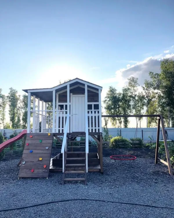 Wooden playhouse with slide and climbing wall