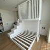 modern loft bed with storage staircase and elevated slatted cabin